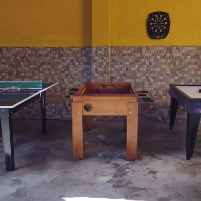 Mesa de ping-pong, totó e air hockey com alvo de dardo ao fundo