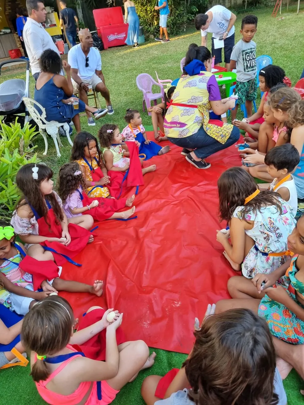 Oficina de massinha do Pula Magia com crianças sentadas em roda ao ar livre
